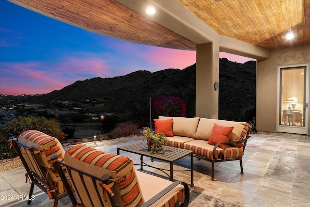 patio terrace at dusk with a mountain view and an outdoor hangout area