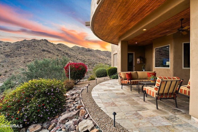 patio terrace at dusk featuring outdoor lounge area and a mountain view