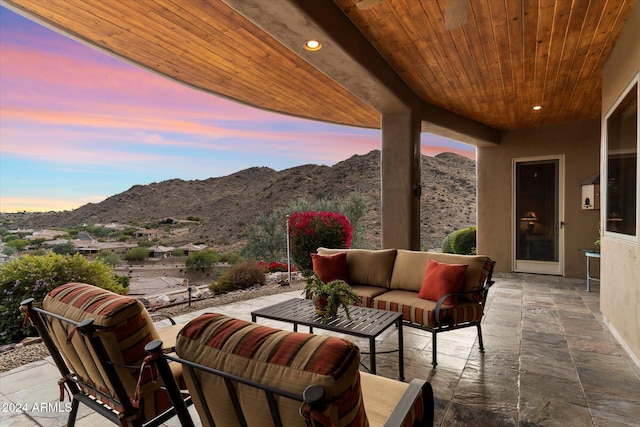 patio terrace at dusk with a mountain view and an outdoor hangout area