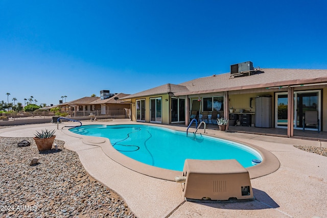 view of pool featuring a patio and central AC