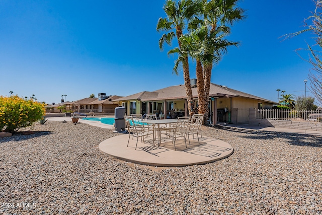 rear view of house with a patio and a community pool