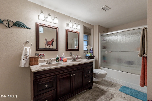 full bathroom featuring combined bath / shower with glass door, vanity, toilet, and tile patterned flooring