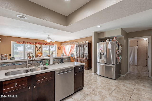 kitchen featuring dark brown cabinetry, ceiling fan, sink, a textured ceiling, and appliances with stainless steel finishes