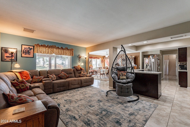 tiled living room featuring a textured ceiling