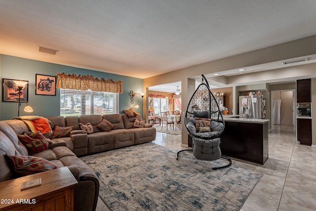 living room featuring a textured ceiling and light tile patterned flooring