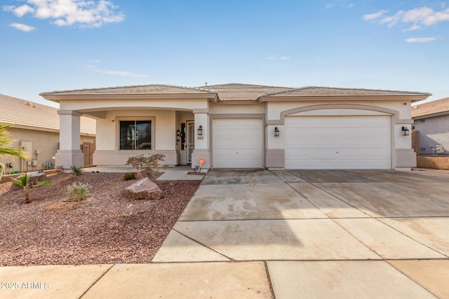 prairie-style house with stucco siding, an attached garage, and driveway