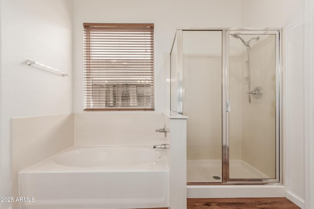 bathroom featuring a stall shower and a garden tub