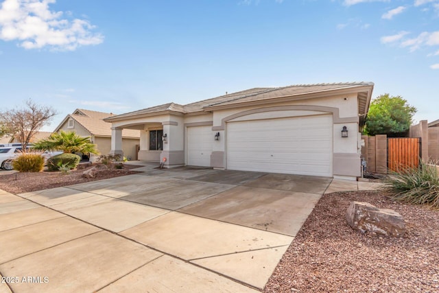 view of front of house featuring fence, a garage, driveway, and stucco siding