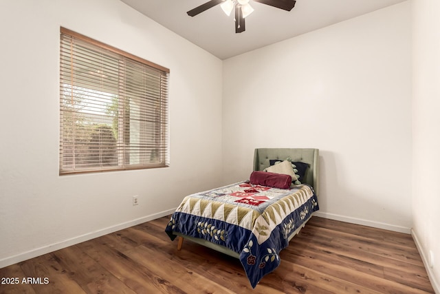 bedroom featuring ceiling fan, baseboards, and wood finished floors