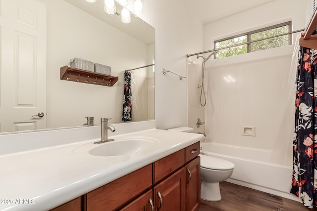 bathroom with vanity, toilet, wood finished floors, and shower / tub combo