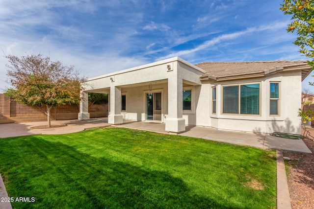 back of property with a yard, stucco siding, a patio, and fence