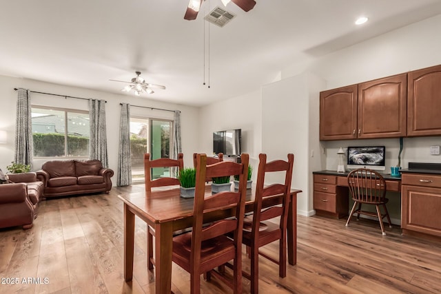 dining area with light wood finished floors, visible vents, recessed lighting, built in study area, and a ceiling fan