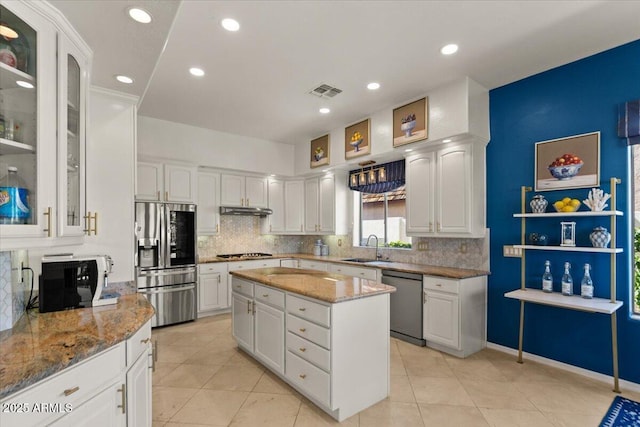 2135 E Clipper Ln, Gilbert, AZ 85234 - kitchen featuring stainless steel appliances, under cabinet range hood, white cabinets, decorative backsplash, and light stone countertops