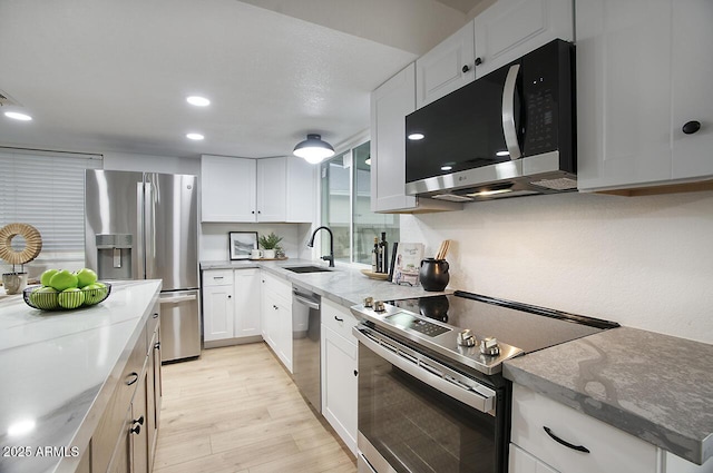 kitchen featuring sink, stainless steel appliances, and white cabinetry