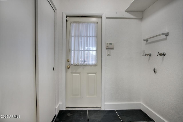 doorway to outside featuring dark tile patterned floors