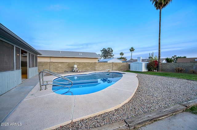 view of pool featuring a patio and a storage shed