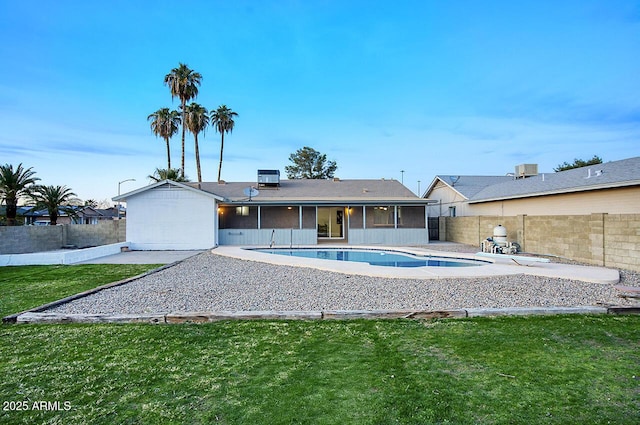 view of pool with a patio area, a lawn, and a sunroom