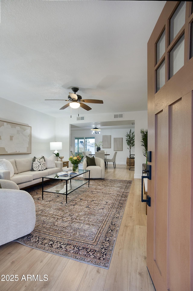 living room with ceiling fan and light hardwood / wood-style flooring