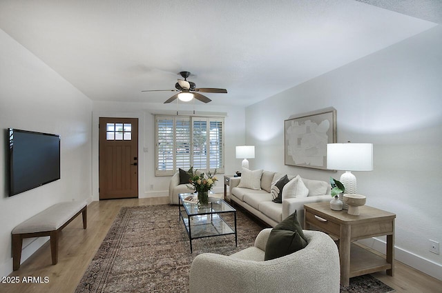 living room featuring light hardwood / wood-style floors and ceiling fan