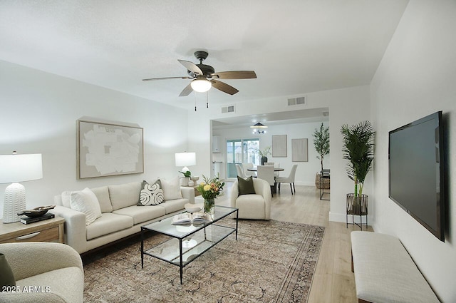 living room featuring ceiling fan and light hardwood / wood-style flooring