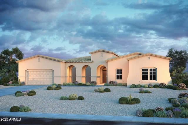 mediterranean / spanish home featuring a garage, concrete driveway, a tiled roof, and stucco siding