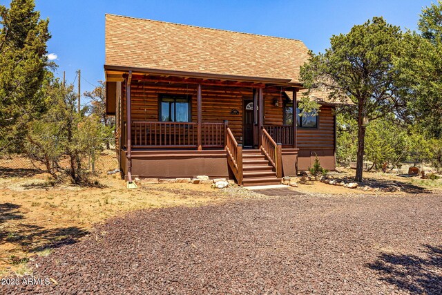 3670 Timberlake Dr, Overgaard, AZ 85933 - view of front of house with covered porch, log veneer siding, and roof with shingles