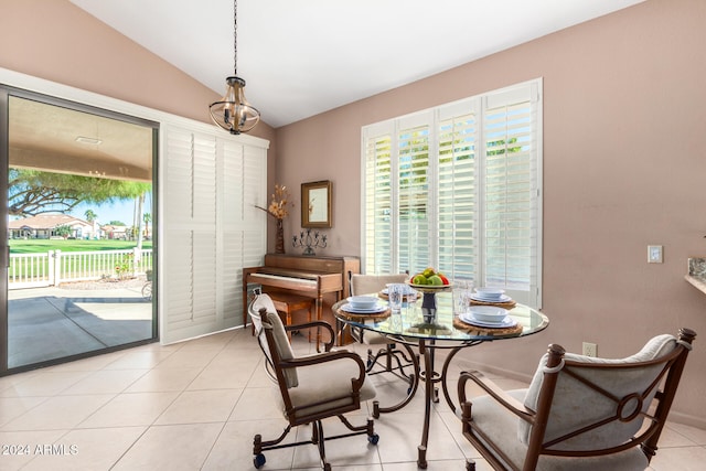 dining room with a chandelier, vaulted ceiling, and light tile patterned floors