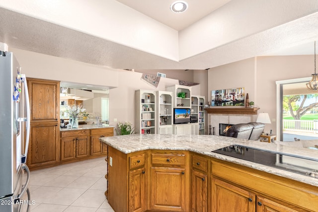 kitchen with black electric stovetop, light stone countertops, stainless steel fridge, lofted ceiling, and light tile patterned floors