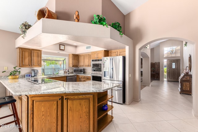 kitchen featuring light tile patterned floors, appliances with stainless steel finishes, sink, and kitchen peninsula