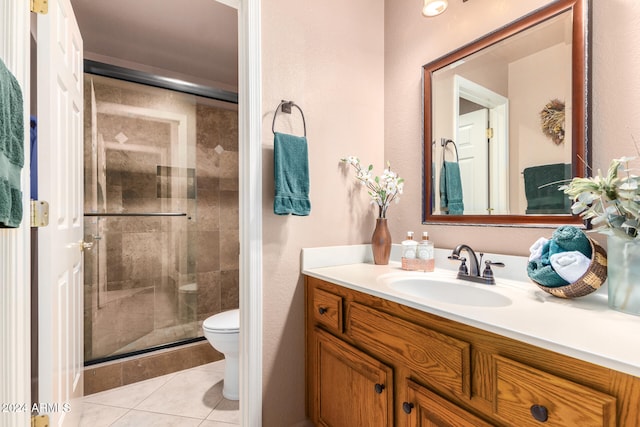 bathroom featuring vanity, a shower with shower door, toilet, and tile patterned floors