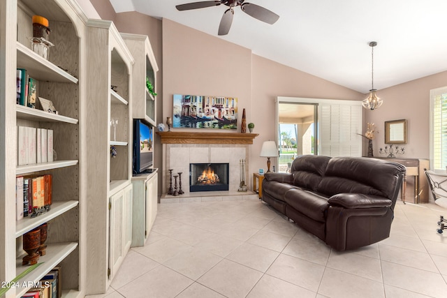 tiled living room with ceiling fan, a healthy amount of sunlight, lofted ceiling, and a fireplace