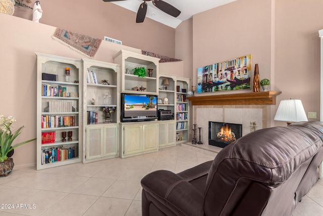 tiled living room featuring a tiled fireplace, vaulted ceiling, and ceiling fan