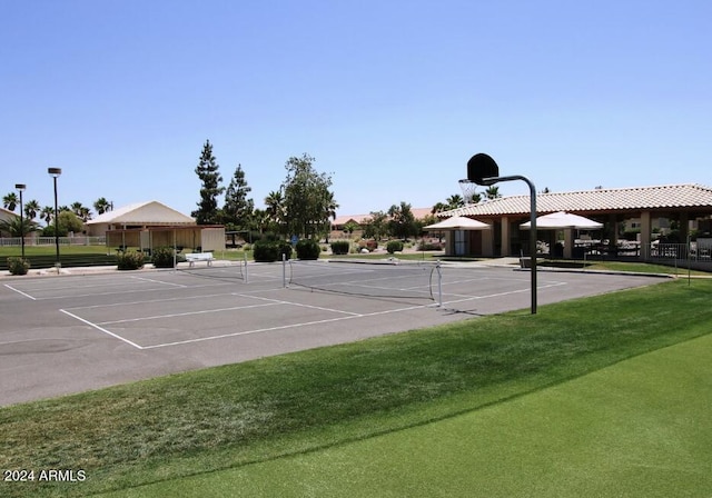 view of sport court with a lawn