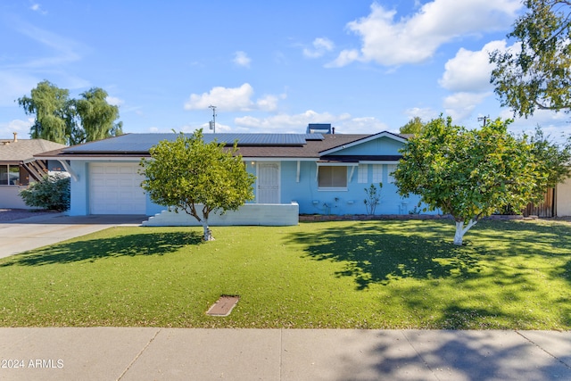 ranch-style home with a front yard, a garage, and solar panels