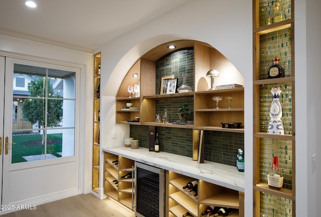 wine room featuring beverage cooler and light wood-type flooring