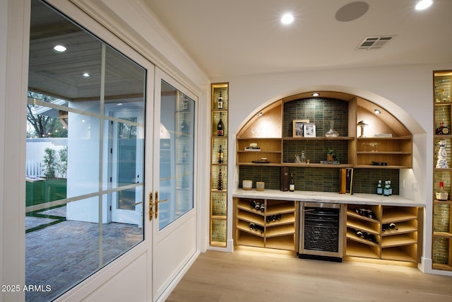 wine room featuring wine cooler, visible vents, recessed lighting, and light wood finished floors