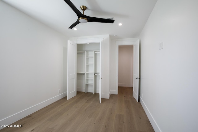 unfurnished bedroom with light wood-style flooring, recessed lighting, baseboards, and a closet