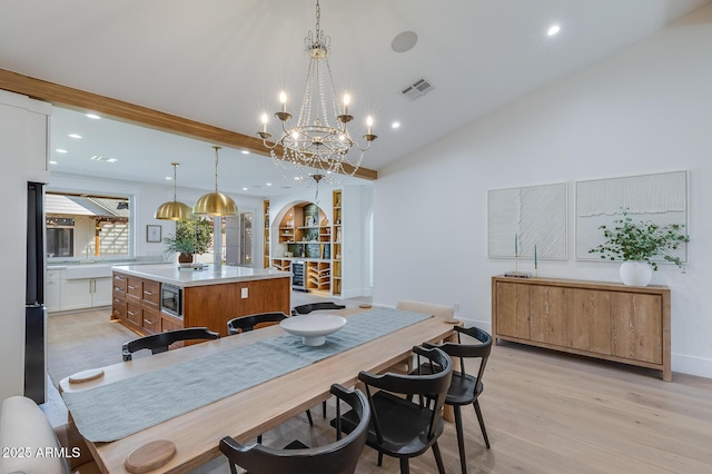 dining area with light wood-style flooring, recessed lighting, arched walkways, and visible vents