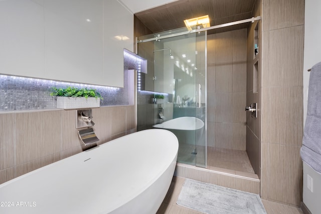 bathroom with tasteful backsplash, shower with separate bathtub, and tile walls