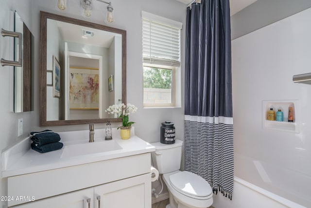 full bathroom featuring shower / bath combo, vanity, and toilet