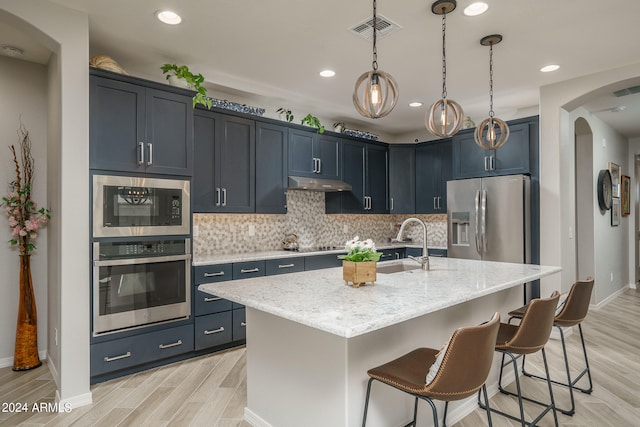 kitchen with black appliances, light hardwood / wood-style floors, light stone countertops, and decorative backsplash