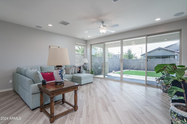 living room featuring light hardwood / wood-style flooring and ceiling fan