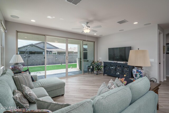 living room with ceiling fan and light hardwood / wood-style flooring