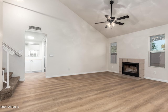 1405 N Jamaica Way, Gilbert, AZ 85234 - unfurnished living room featuring high vaulted ceiling, stairway, ceiling fan, light wood-style floors, and a tile fireplace