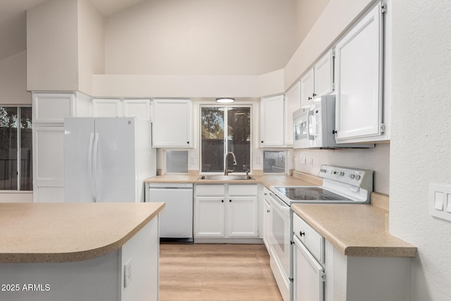 1405 N Jamaica Way, Gilbert, AZ 85234 - kitchen featuring white appliances, light wood-style floors, white cabinetry, light countertops, and a towering ceiling