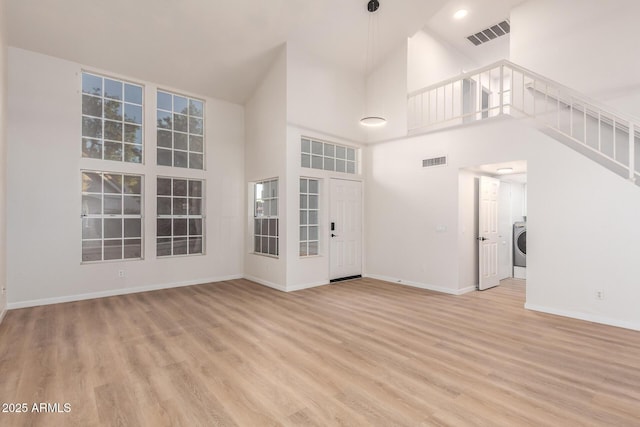 1405 N Jamaica Way, Gilbert, AZ 85234 - unfurnished living room with a high ceiling, washer / clothes dryer, and light wood-style flooring