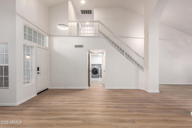 1405 N Jamaica Way, Gilbert, AZ 85234 - entryway with washer / clothes dryer, high vaulted ceiling, stairs, arched walkways, and wood finished floors