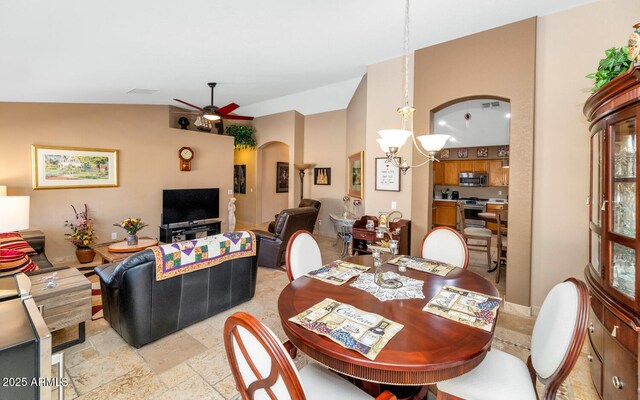 15740 N 91st Dr, Peoria, AZ 85382 - dining space featuring arched walkways, a chandelier, lofted ceiling, a ceiling fan, and stone tile floors