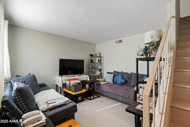 living room with light hardwood / wood-style floors and a textured ceiling