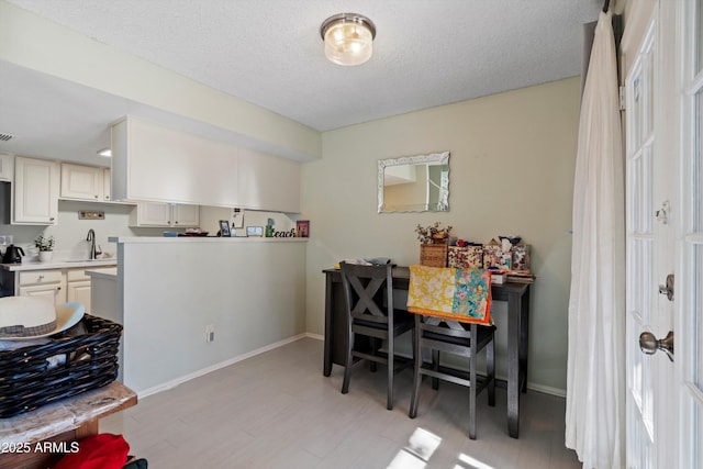 dining room with a textured ceiling and sink